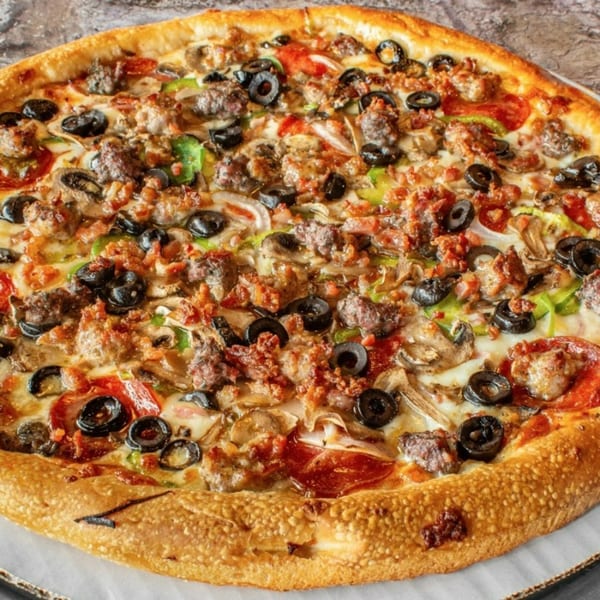 Stavro's Pizza House IV's fully loaded pizza with pepperoni, sausage, olives, mushrooms, and peppers.